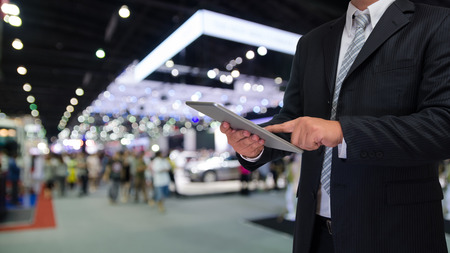 business man using tablet with blurred event backgroundの写真素材