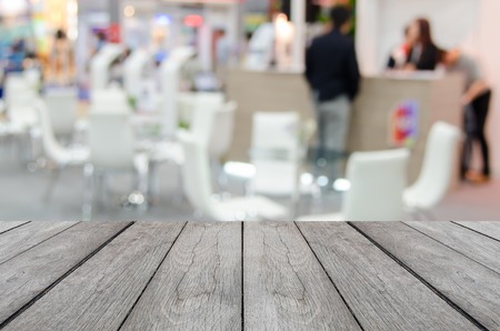 white wood table with blurred event background