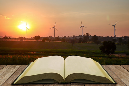 open book with wind turbine field backgroundの写真素材