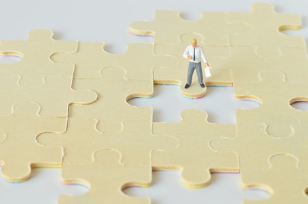 miniature worker on jigsaw puzzleの写真素材