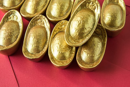 Chinese golden ingots and red envelope on wooden table : Chinese new year themeの写真素材