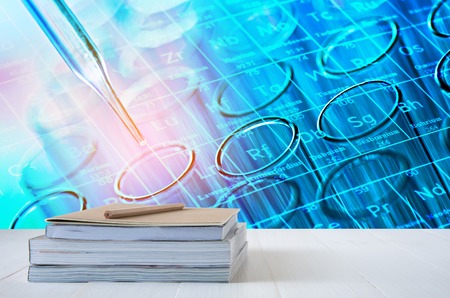 book stack on white table with science laboratory test tubes backgroundの写真素材