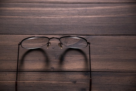 brown eyeglasses on wood tableの写真素材