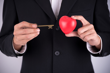 businessman using a key to unlock the heartの写真素材