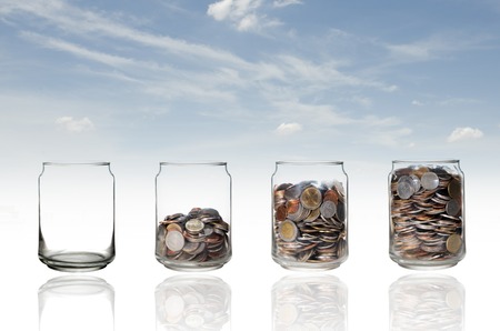 saving glass jar on sky backgroundの写真素材