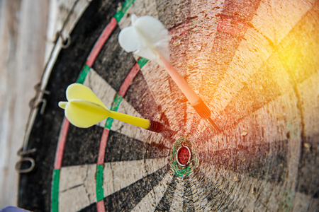 vintage darts hit on old dartboardの写真素材