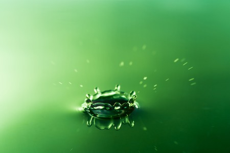 water drop dropping on water surfaceの写真素材
