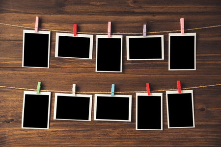 empty photo frames hanging with clothespins on wooden backgroundの写真素材