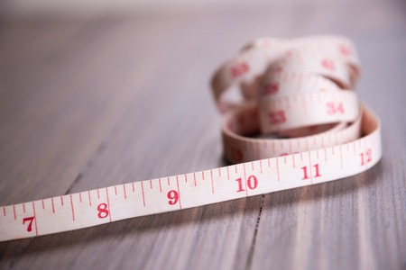 white measuring tape on wood background focus on 9 inch longの写真素材