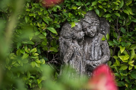 statues with green leaves background in gardenの写真素材