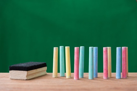 chalks in a variety of colors and brush on table with green background ,back to school conceptの写真素材