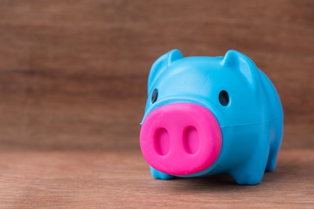 plastic blue piggy bank on wooden tableの写真素材