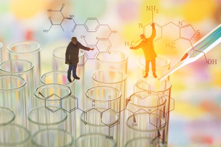 Miniature scientist technical team checking chemical in laboratory test tubeの写真素材