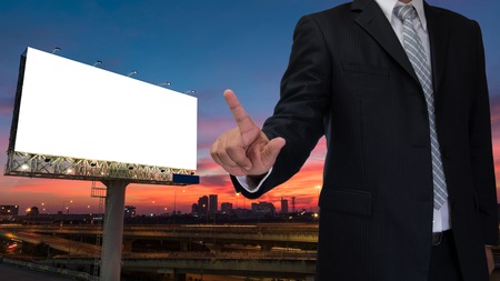 businessman and blank billboard at twilight sky sunset ready for an advertisement