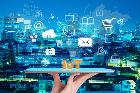 woman hand using smart phone in concept internet of things with night modern city backgroundの写真素材