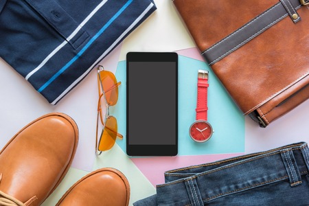 mobile phone and flat lay of men's casual fashion on white wooden floorの写真素材