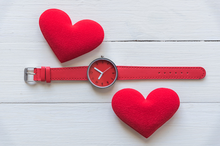 couple red heart with watch on wooden backgroundの写真素材