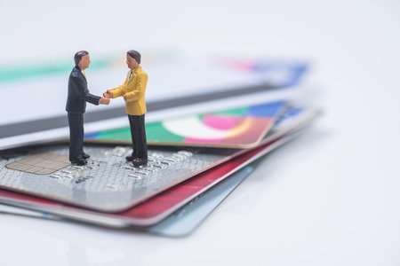 business miniature people shaking hands on credit card stack backgroundの写真素材