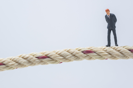 business miniature people walking on a ropeの写真素材
