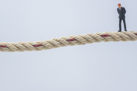 business miniature people standing on a ropeの写真素材