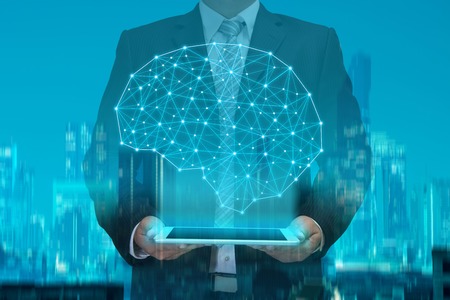 double exposure of business man using tablet showing digital brain model on night modern city...