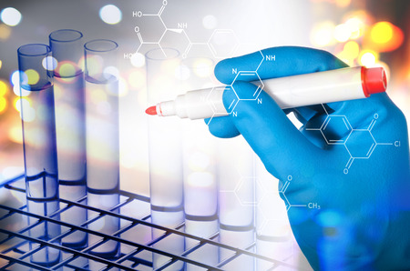 scientist hand in blue glove holding red marker for writing science formula