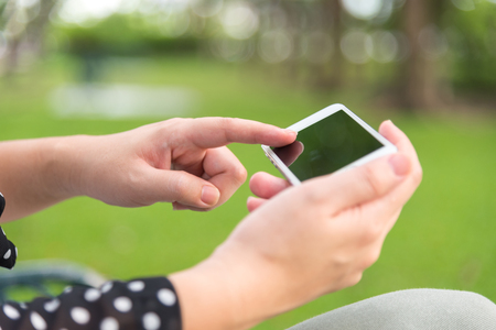 woman using tablet while sitting for relax in green parkの写真素材