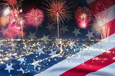 double exposure of fireworks over night city and USA flagの写真素材