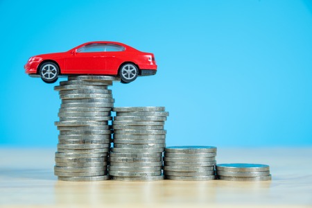 red miniature car model on stack of coinsの写真素材
