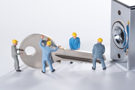 miniature people try to unlock metal keyの写真素材