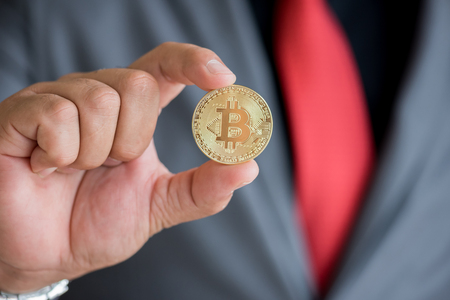businessman hand showing gold bitcoin digital currencyの写真素材