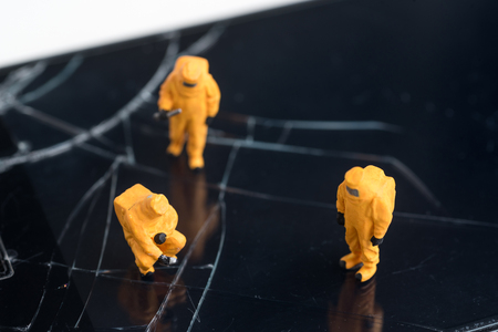 miniature people are inspect  the fracture on smartphone screen