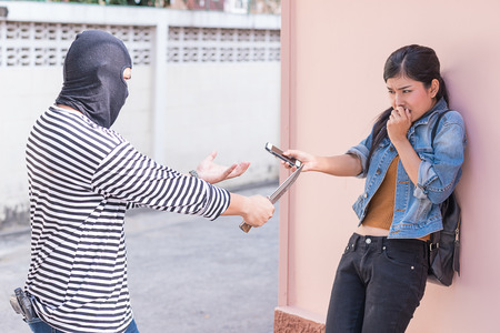 thief stealing smart phone from traveler womanの写真素材
