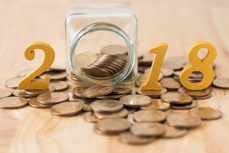 coins splash out from glass bottle and text year 2018.