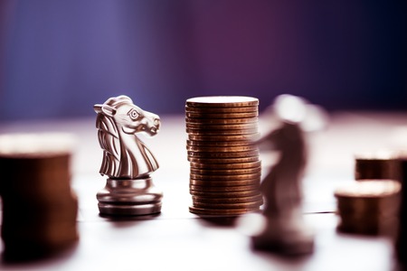 chess pieces and stack of coins on a chessboard, business strategy conceptの写真素材