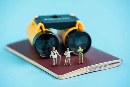 miniature traveler and binoculars on passport bookの写真素材