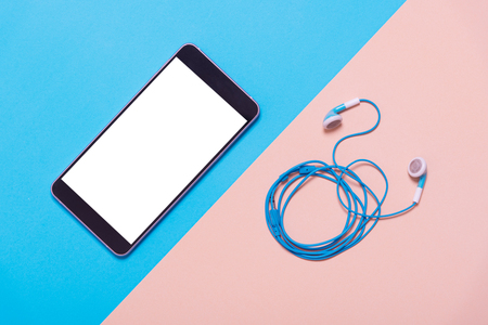 flat lay of smart phone and earphones on color paper , minimal style backgroundの写真素材