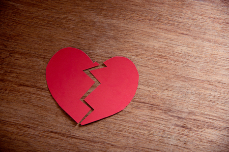 red paper broken heart on wood background , concept of loveの写真素材