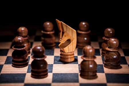 white knight chess surrounded by a number of white chess pieces , business strategy conceptの写真素材