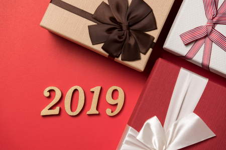 wood text year 2019 and gift box on red background for happy new year