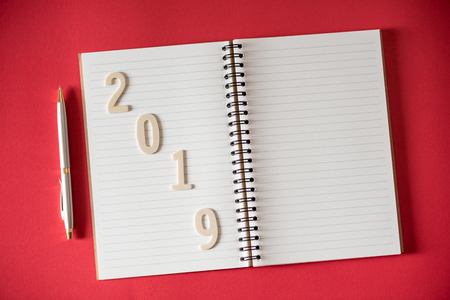 wood number 2019 on a page of blank note book with a penの写真素材