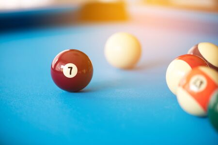 pool balls on light blue table , focus on lucky number 7