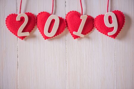 rows of red heart with text 2019 hanging on white wood wall backgroundの写真素材