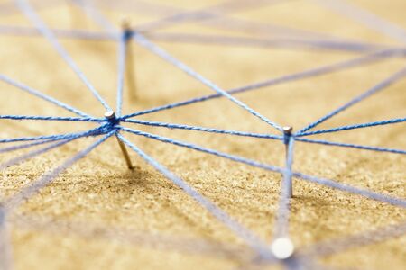 abstract web line connection of color yarn from nail node to node on white background, networking conceptの写真素材