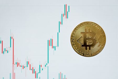 crypto currency bitcoin with candle stick graph on white screen backgroundの写真素材