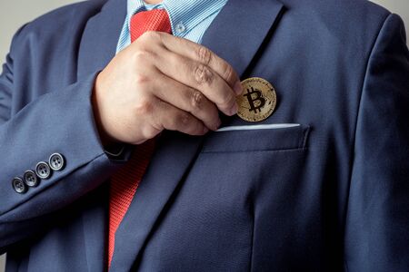 businessman pick up bitcoin digital currency from pocketの写真素材