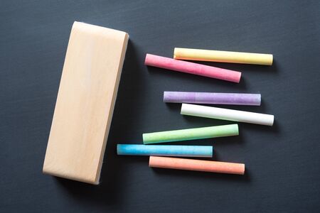 multicolor chalk stick on black chalkboard background