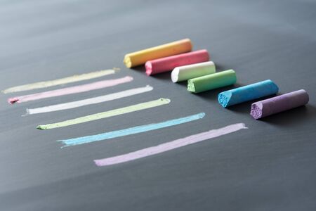 multicolor chalk stick on black chalkboard backgroundの写真素材