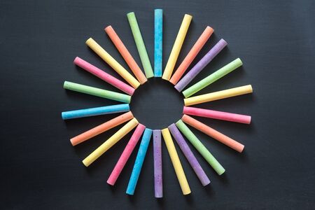multicolor chalk stick on black chalkboard background