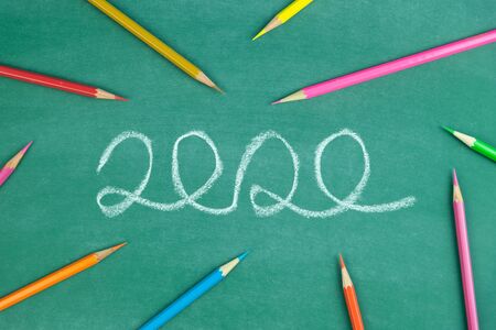 chalk write 2020 text and color pencil on green chalk boardの写真素材